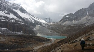 雪山下的徒步者与湖泊