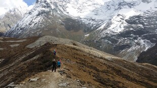 徒步者穿行于雪山山间