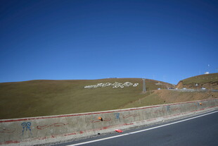 公路旁的绿色山坡与蓝天