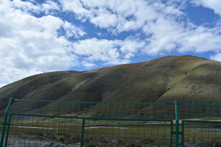 草原山丘与蓝天围栏景象