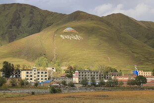 山坡下的建筑与多彩旗帜