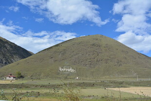 青山蓝天白云下的草地景观