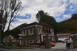 山间特色小屋前的行人