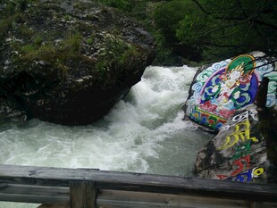 彩色涂鸦旁的湍急溪流