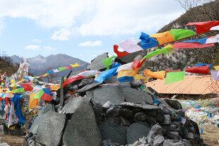 藏区经幡飘扬于山石间