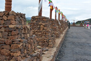 石砌矮墙与彩色经幡景观 稻城
