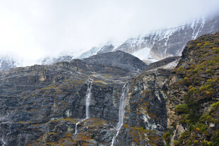 山间瀑布与巍峨雪山景观 稻城