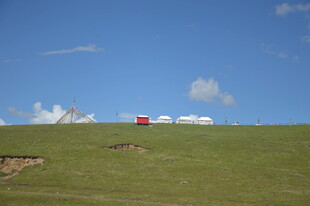 草原上的红车与白色帐篷