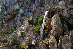 山间瀑布垂落于嶙峋怪石