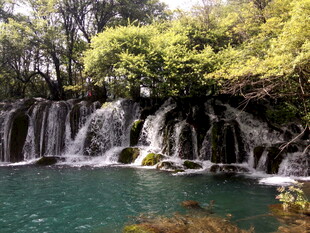 山间秀丽瀑布下的碧绿潭水