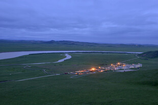 草原暮色中的村落与河流