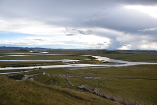 草原河流与多云天空景观