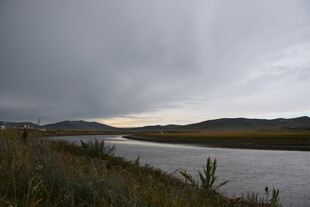 阴沉天空下的静谧河畔