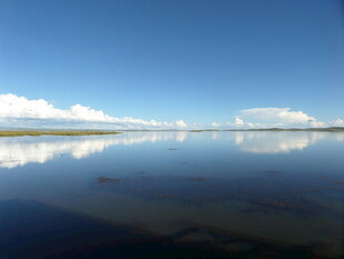 平静湖面映蓝天白云