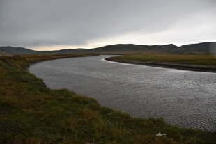 蜿蜒河流与阴沉天色景观