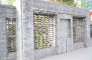 灰色镂空砖墙 绿植点缀