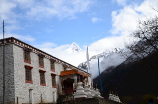 藏式建筑旁的雪山美景