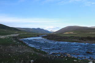 山间溪流蜿蜒于绿野