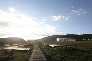 草原上的木栈道与远处建筑