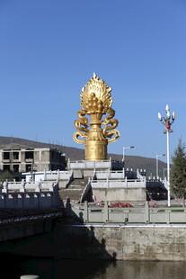 金色宏伟雕像立于水边