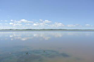 平静湖面映蓝天与白云