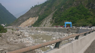 山间河道旁的蓝色建筑