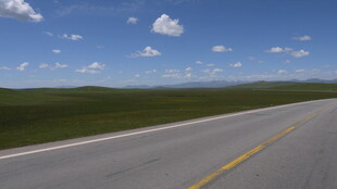 宽阔公路延伸至草原天际