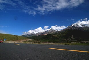 公路伸向雪山蓝天美景