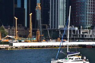 城市港口边的帆船与塔吊