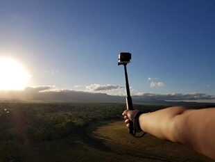 日出美景下的手持自拍杆