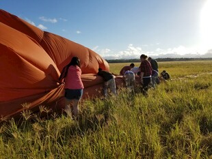 田野中众人操作大型橙色物