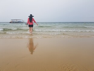 女子漫步于海边沙滩