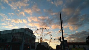 夕阳下的摩天轮与城市景象