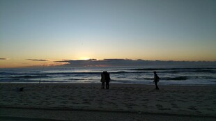 黄昏海滩上的漫步身影