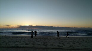 夕阳下的海边漫步身影