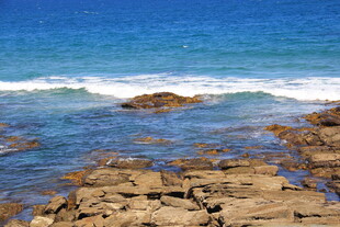 海边礁石与翻涌的蓝色海浪