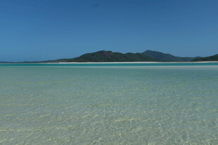 清澈海滩与远处山峦美景