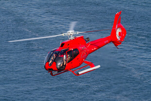 红色直升机翱翔于海面