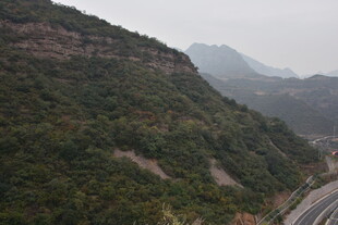 山间公路蜿蜒于葱郁山峦