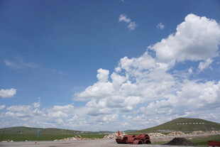 蓝天旷野中的红色车辆