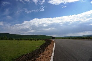 宽阔公路旁的绿野蓝天