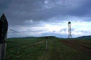 草原上的铁塔与阴沉天空