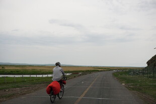 公路骑行者与红色驮包