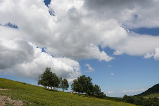 蓝天白云下的绿意山丘