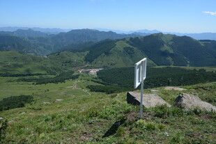 山顶路标旁的开阔山野景色