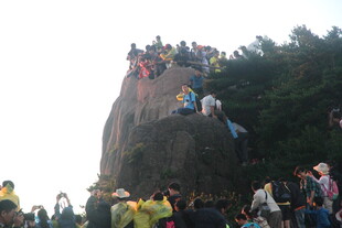游客攀登巨石热闹场景
