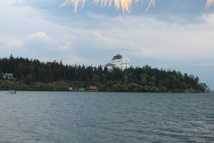 湖畔灯塔与茂密树林景观