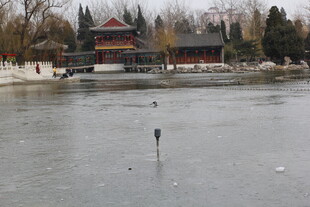 冬日结冰湖面旁的中式建筑