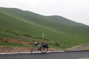 公路骑行者穿梭于青山间