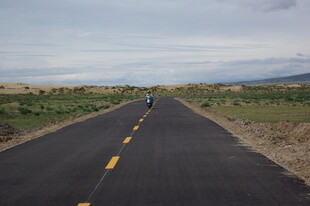 空旷公路上的孤独骑行者